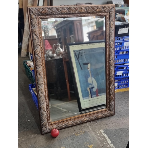 487 - A very large beveled wall mirror with ornate copper toned frame boasting attractive egg and dart bor... 