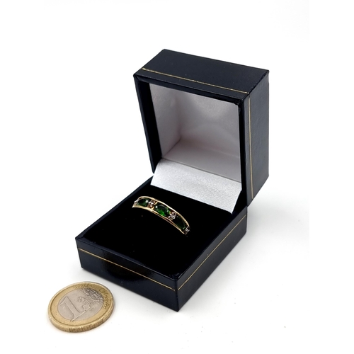 543 - A most attractive vintage four stone Peridot ring, set with Diamond accents on a silver gilt thick b... 