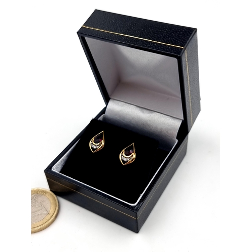 552 - A pretty pair of 9 carat gold plated Garnet and White Sapphire tear drop stud earrings. Set with but... 