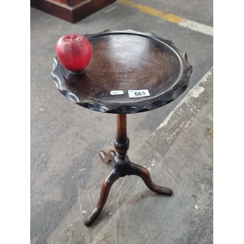 563 - An antique wooden wine table with tripod pillar base and scalloped edge.