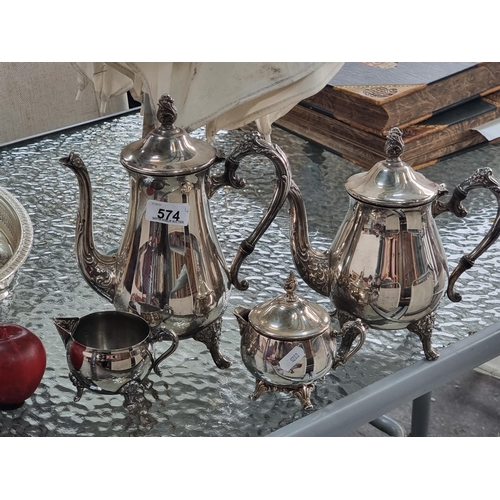 574 - Four silver plated items including a teapot, coffee pot, lidded creamer and an additional creamer. A... 