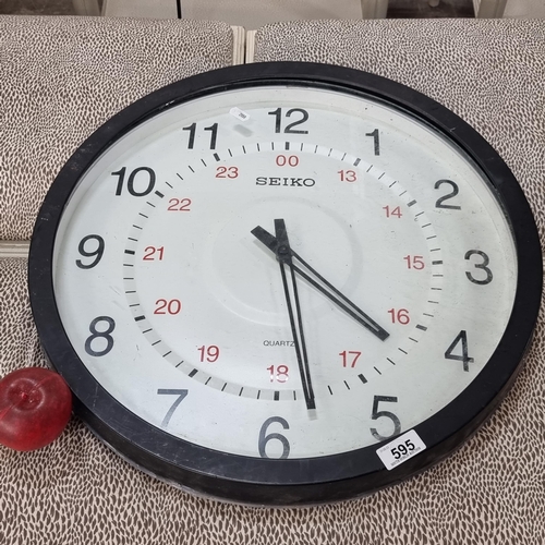 595 - A large wall clock made by Seiko with black frame.