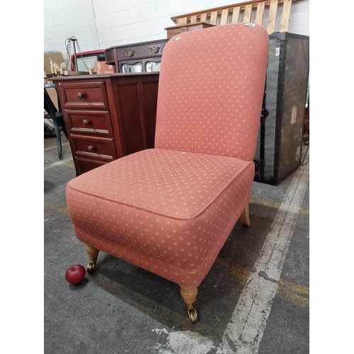 606 - A charming nursing chair with wide comfortable seat upholstered in a terracotta star pattern fabric.