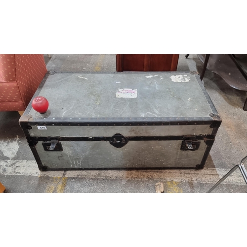 610 - A reinforced vintage travel chest with profuse studwork and genuine leather handles. Featuring label... 