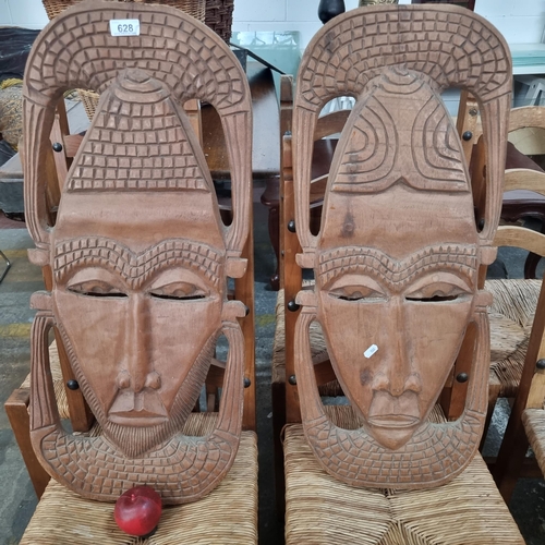 628 - A very large pair of carved African wall hangings in the form of masks. Featuring both male and fema... 