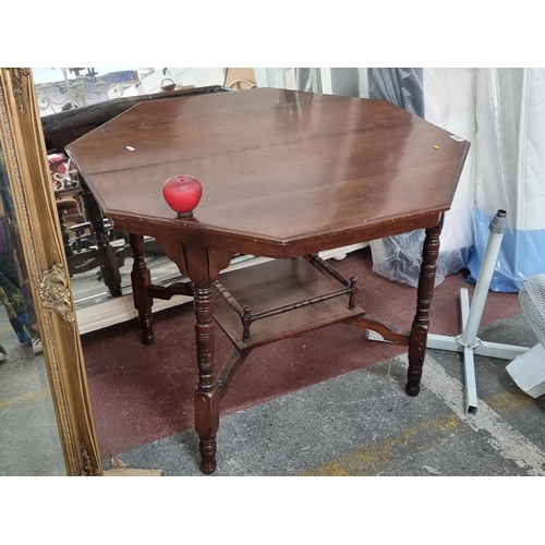 645 - An elegant vintage octagonal centre table of two tiers. Featuring turned legs and a neat sized raile... 