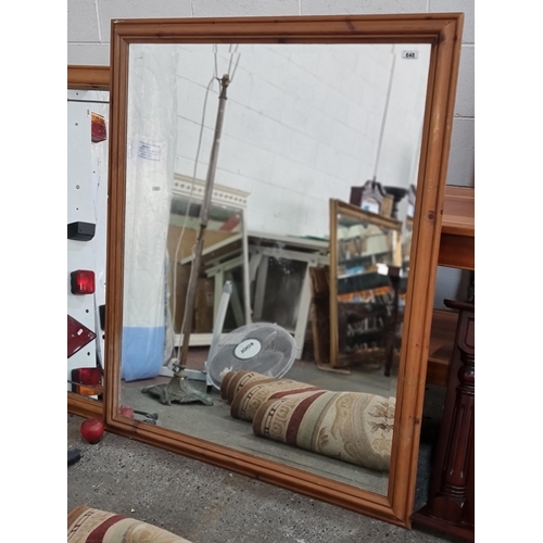 648 - A large bevelled wall mirror housed in simple pinewood frame. H128cm x W104cm