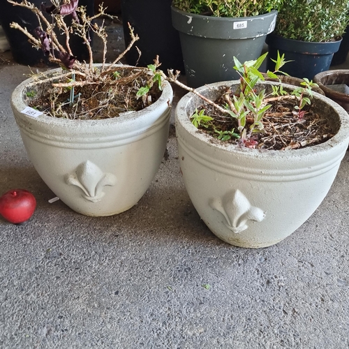 681 - A pair of heavy  stone outdoor planters with a high relief fleur de lis detail to side. H26cm x D33c... 