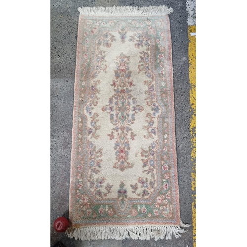 731 - A charming wool hall runner rug in pastel shades of pink, green and blue on a cream ground. With a t... 