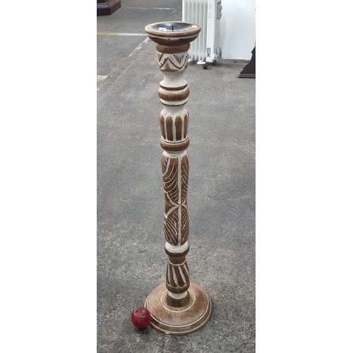 561 - An attractive tall turned and carved wooden floorstanding candlestand. Featuring distressed plaster ... 