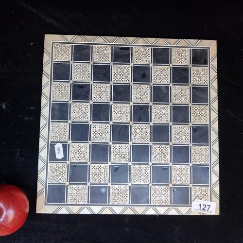 127 - A fabulous chess board made of lacquered wood and inlayed with mother of pearl parquetry detail. A s... 