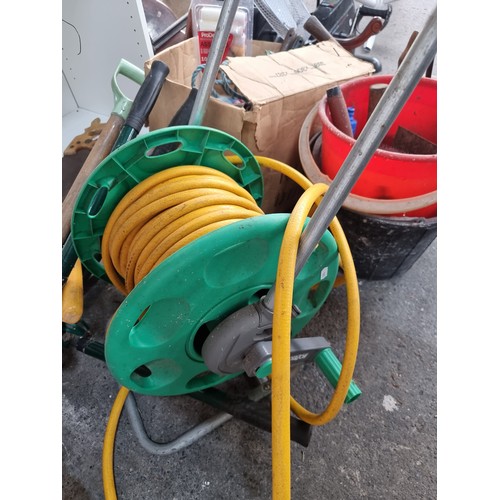 654 - A HoZeLock garden hose reel with a large quanity of mixed tools including spanners chisels, a German... 