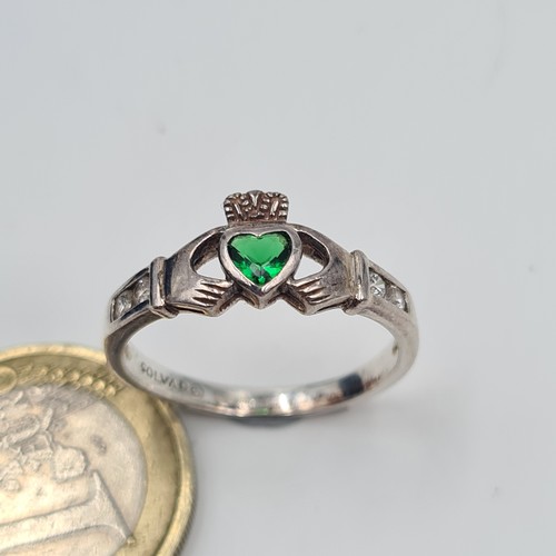 513 - An attractive example of a sterling silver hallmarked Claddagh ring, set with a bright May birth sto... 