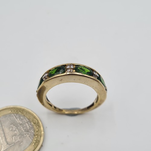 543 - A most attractive vintage four stone Peridot ring, set with Diamond accents on a silver gilt thick b... 