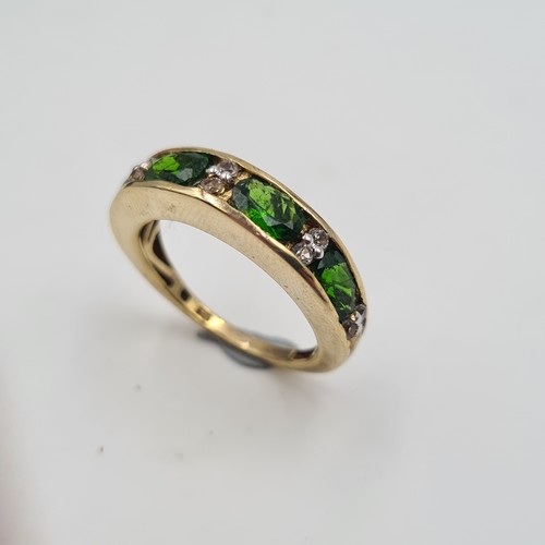 543 - A most attractive vintage four stone Peridot ring, set with Diamond accents on a silver gilt thick b... 