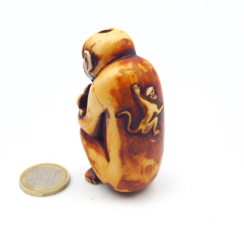 A hand carved antique Japanese Netsuke, in the form of amonkey. Height ...