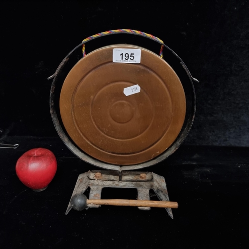 195 - A tabletop gong with a copper disc and a wooden beater with a rubber end.