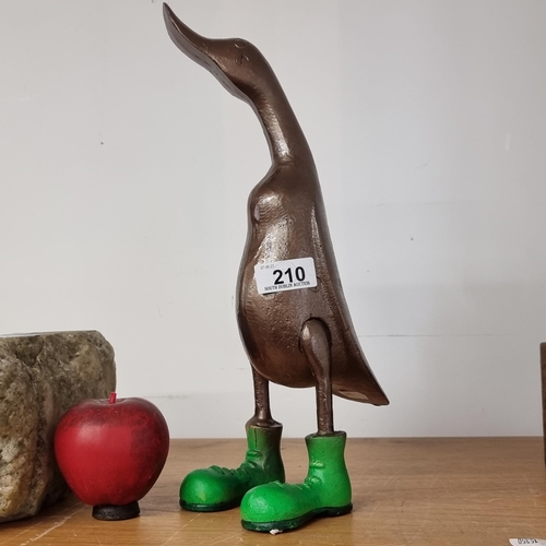 210 - A very charming and heavy cast metal sculpture of a duck wearing bright green wellington boots.