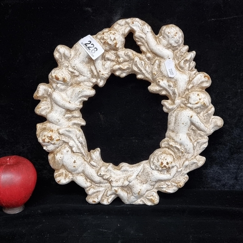 228 - A very heavy cast metal wall wreath formed by intertwined cherubs.