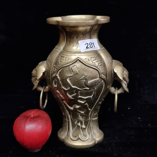 281 - A wonderful heavy solid brass vase boasting elaborate etched foliate motifs and ring handles.