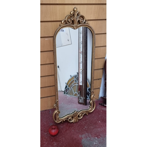 328 - A tall wall mirror with ornate gilt frame with fleur-de-lis and rope motif edging.