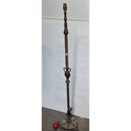 445 - A heavy quality ornate floor standing antique lamp with a cast metal base in the form of a cherub ho... 