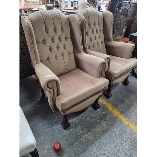 482 - A pair of vintage Victorian style wing back armchairs. Sporting button backs and a plush camel uphol... 