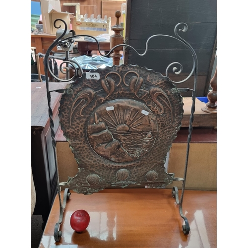 484 - An unusual repoussé copper fire screen sporting a coastal scene with a beaming horizon in the backgr... 