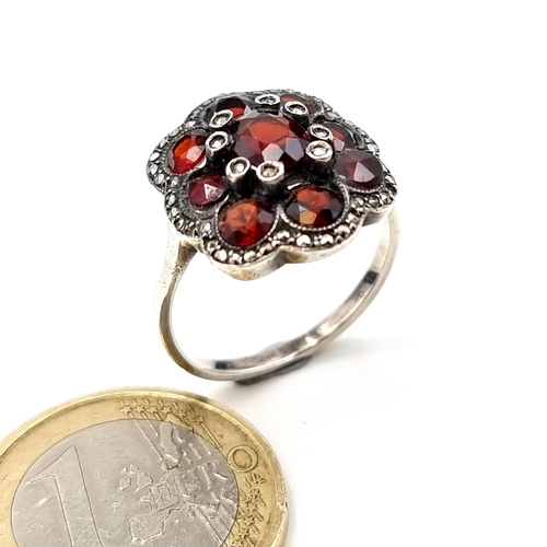 539 - A very attractive 9 stone Garnet floral ring, set with Marcasite setting and surround. Ring size: Q.... 