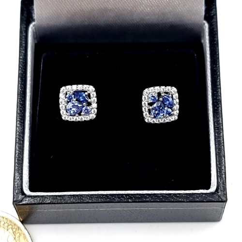 542 - A pair of beautiful Tanzanite stud earrings, set with White Sapphire surrounds. Ring set in sterling... 