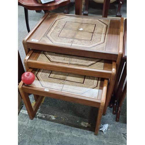 576 - Star Lot : A super attractive trio of mid century nesting tables; with very cool open teak frames an... 