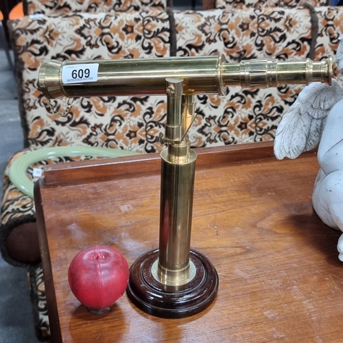 609 - A wonderful mounted brass toned telescope with lens cap attached and set on a wooden base.