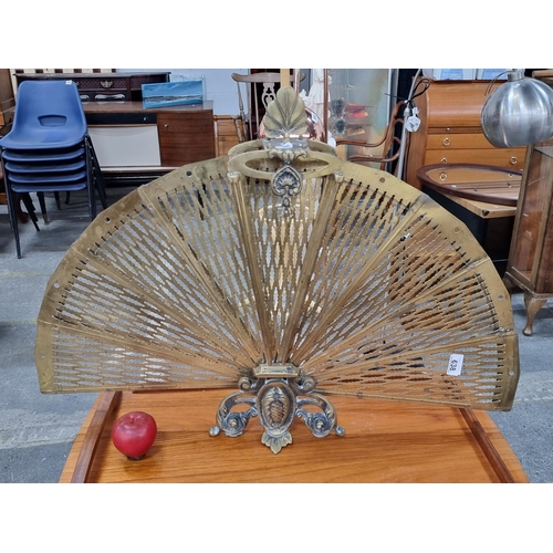 638 - A lovely example of an antique brass peacock fireguard. Featuring leaf  finial and sculptural base.