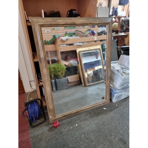 735 - A very large wall mirror with bevelled glass housed in a gilt wooden frame. Mm: 120 x 91 cm