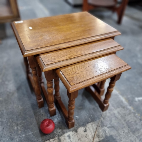 646 - A set of three honey oak nicely crafted nesting tables with turned wood legs and attractive wood gra... 