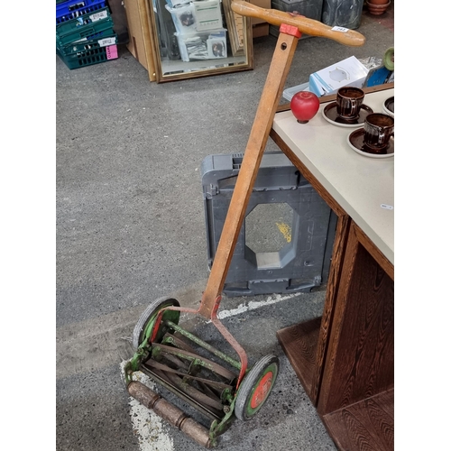 743 - A vintage push mower made by Folbate with a long wooden stem and large rubber wheels. Working well.