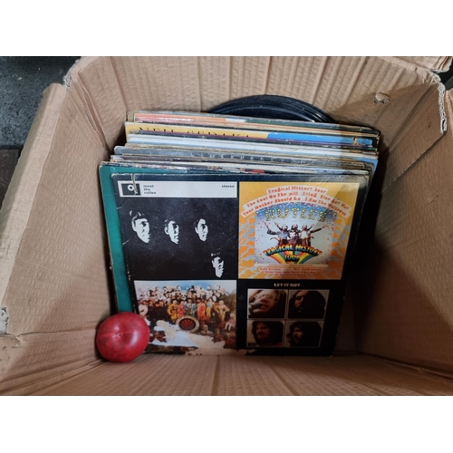 750 - A box containing a selection of 63 vinyl record albums and singles in a wide range of genres.