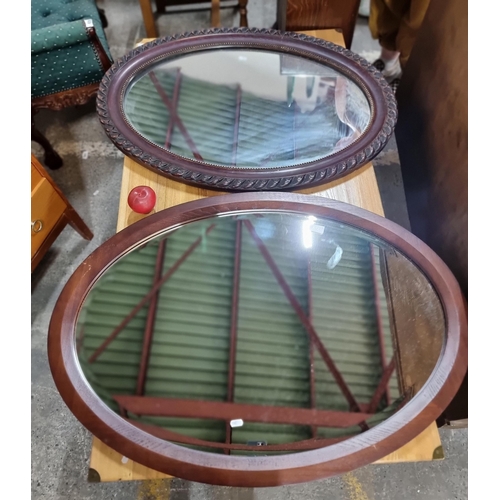 656 - Two large oval wall mirrors with ornate wooden frames.