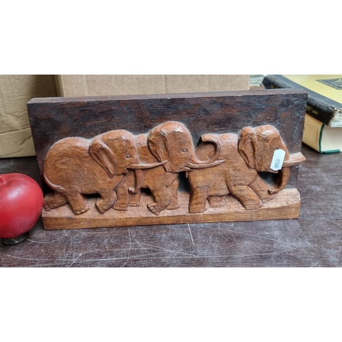 756 - A hand carved solid wood panel featuring three elephants in high relief.