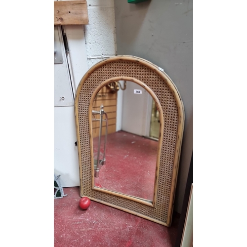 766 - A large wall mirror with a thick wicker frame. H94cm x W62cm