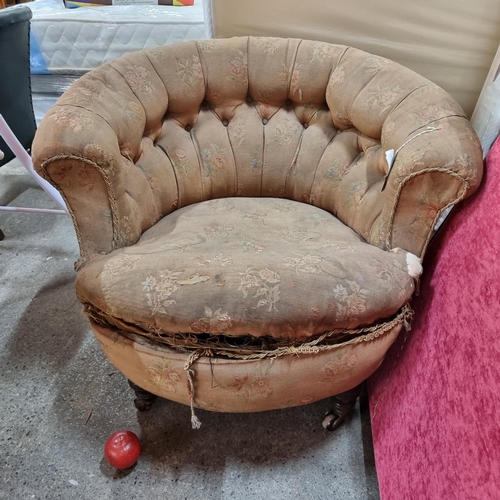 671 - A Victorian round tub chair with button back and rope lining on turned wooden legs on castors. Needs... 