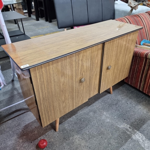 773 - A vintage credenza with three internal shelves concealed by two cupboard doors finished with ornate ... 