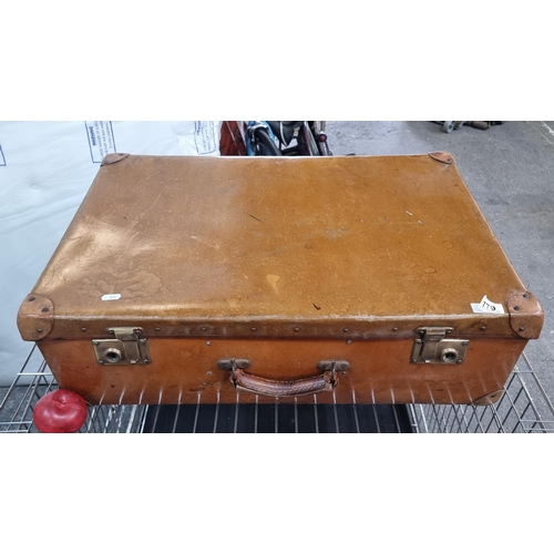 779 - A large vintage leather hard travel trunk with brass hardware and stud reinforcements with carry han... 