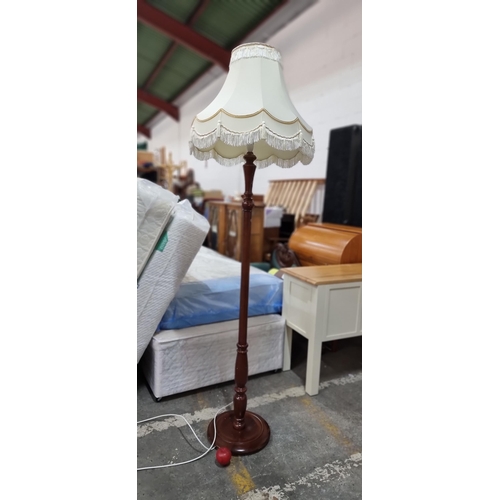 680 - A vintage floor standing lamp with reeded stem and beveled circular base topped with a cream fringed... 