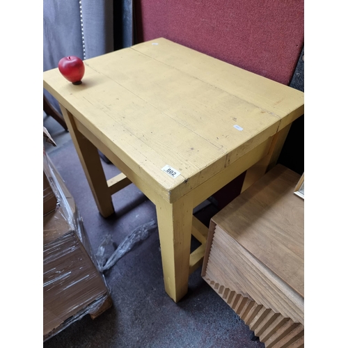 802 - A neatly proportioned solid wooden table with stretcher to base and finished in a sunshine yellow. M... 