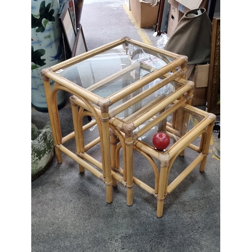 808 - A set of three nesting tables made of bentwood bamboo frame and tempered glass tops.