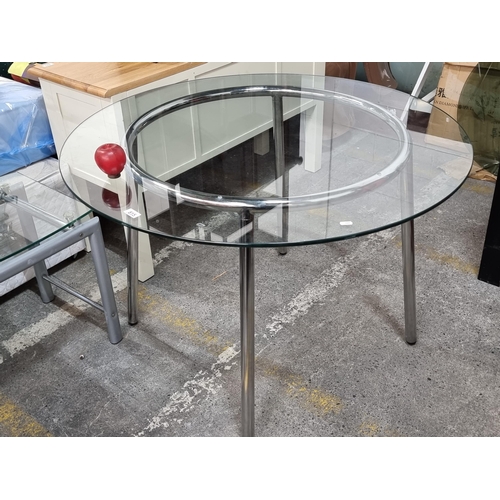 815 - A sleek circular dining table with polished chrome tube legs and a tempered glass top. Mm: Diameter ... 