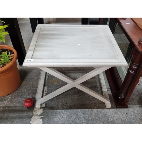 824 - A delightful wooden side table in grey with x frame stretcher base.