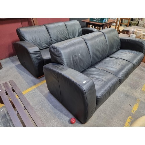 688 - A pair of stylish three-seater, black leather sofas with very comfortable padded seats and backs, an... 