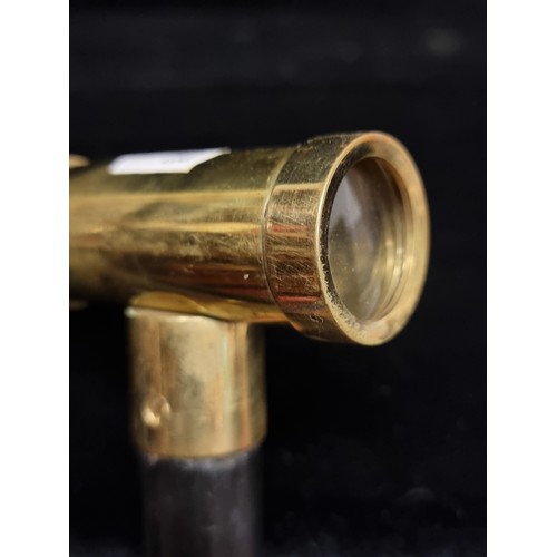 272 - An unusual walking cane with an integrated spyglass handle in a brass tone.